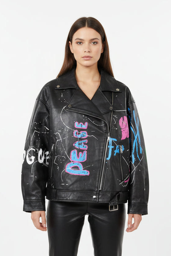 Woman wearing a black leather jacket with colorful text and designs on a white background
