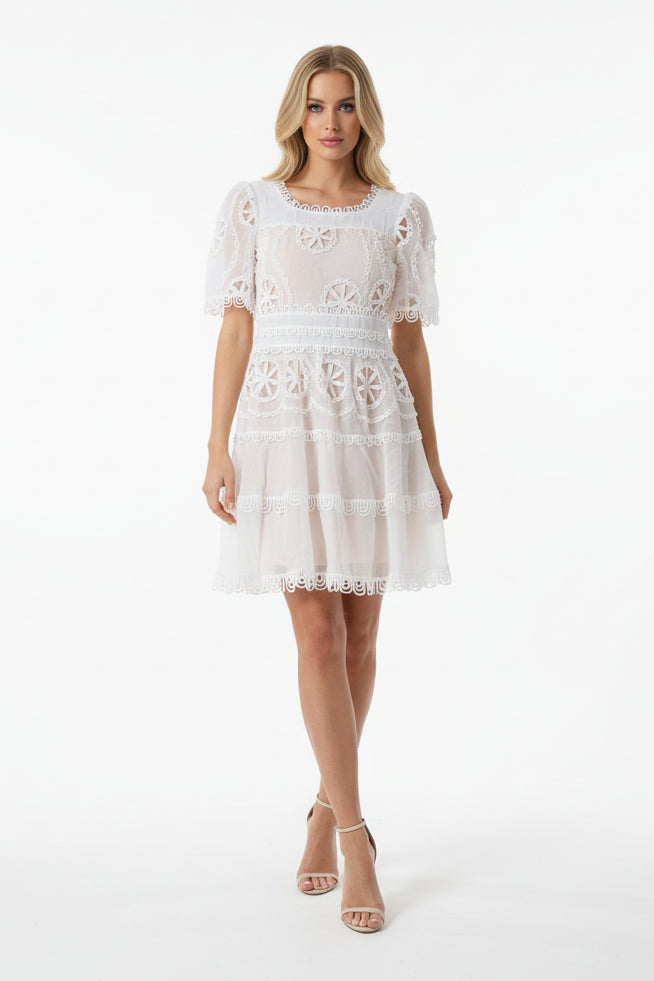 Woman wearing a white lace dress on a white background