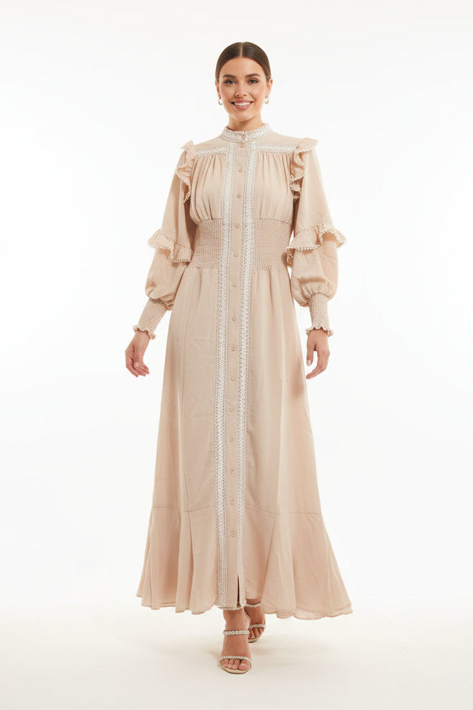 Woman wearing a beige dress with ruffled sleeves on a white background